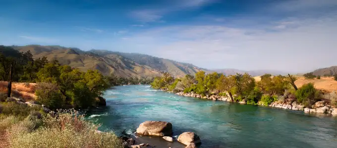 Turquoise river flowing through the lush, rolling Sierra Nevada foothills — the stunning natural setting of the Bella Vista Inn.